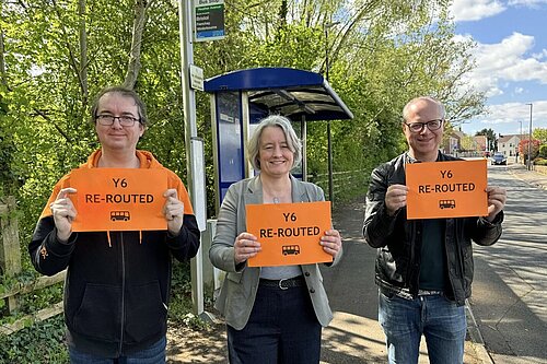 Jon, Claire and Tristan holding "Y6 Re-routed" signs