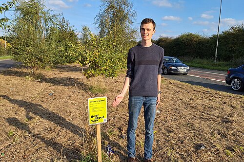 Lib Dem Campaigner Caleb Pell by the ‘Buzz about York’ sign with litter all around