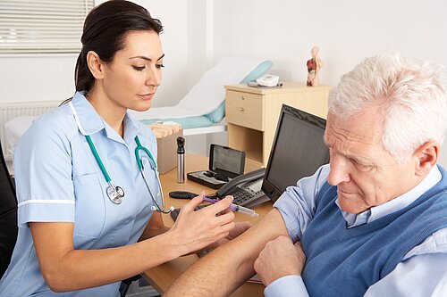 A nurse giving an injection to an old man.