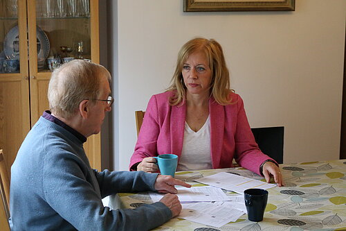 Liz speaks with man at table