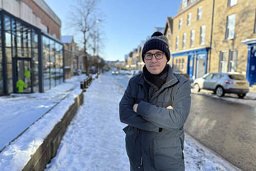 Tom Gordon stood in a hat scarf and coat on Westmorland Street in the snow