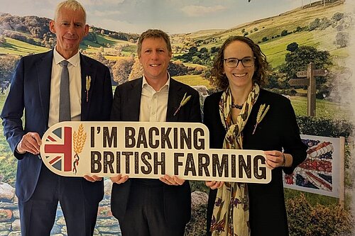 James MacCleary with fellow LibDem MPs Alison Bennett and John Milne holding a sign that says "I'm backing British farming"