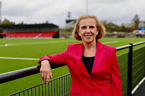 Susan Murray, Mid Dunbartonshire candidate for the Scottish Liberal Democrats, leaning on a fence next to a football pitch.